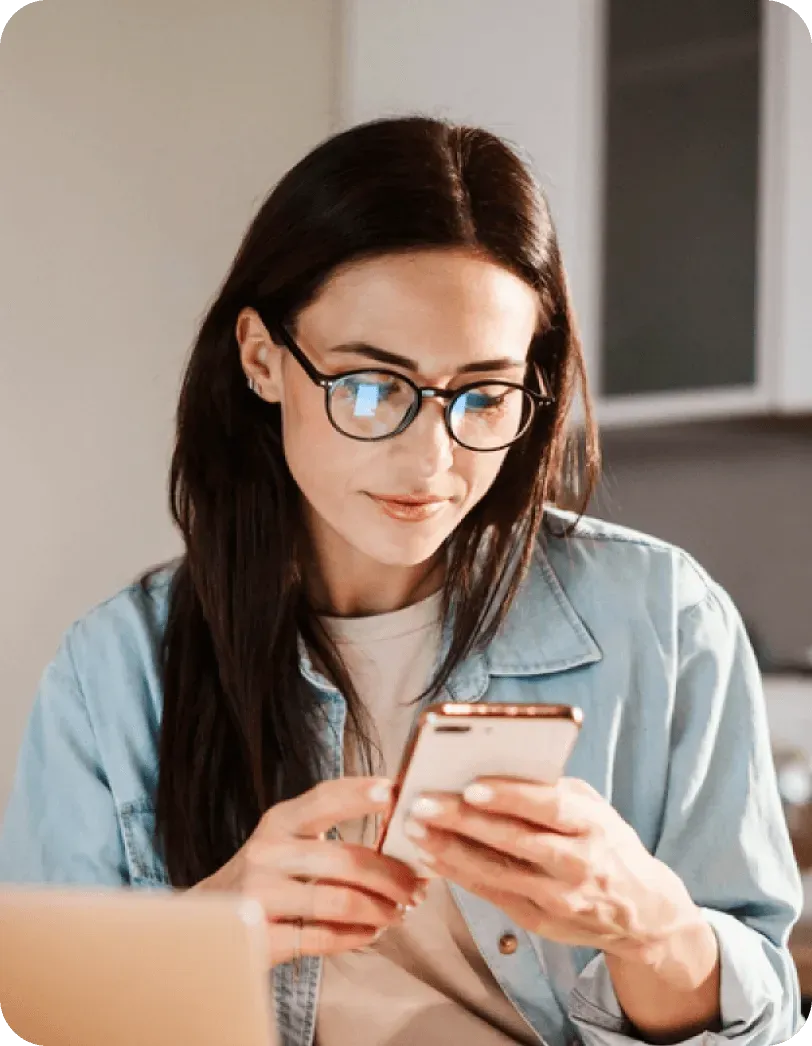 Woman smiling while using the Yuna app on her phone